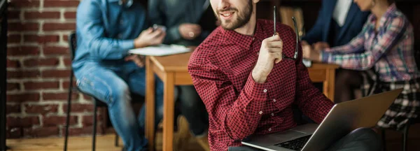 Direktör i bolaget med laptop på bakgrunden av business — Stockfoto