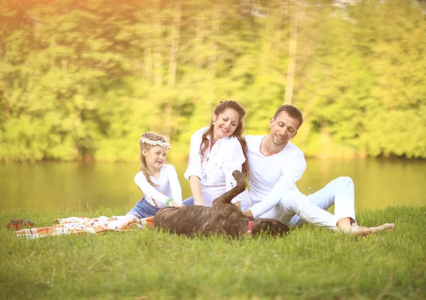 Glückliche Familie mit Hund beim Picknick an einem sonnigen Sommertag. pregn — Stockfoto