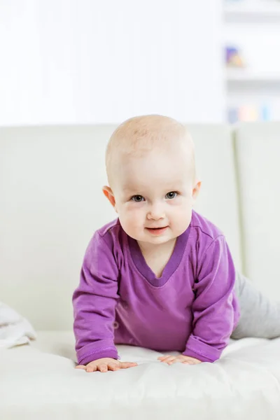 Portrait of a happy one year old baby girl on a background of bright childrens room — Stock Photo, Image