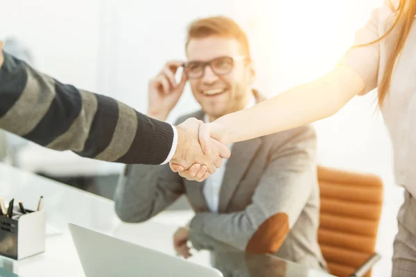 Handshake of business partners on the background of the professional employee — Stock Photo, Image