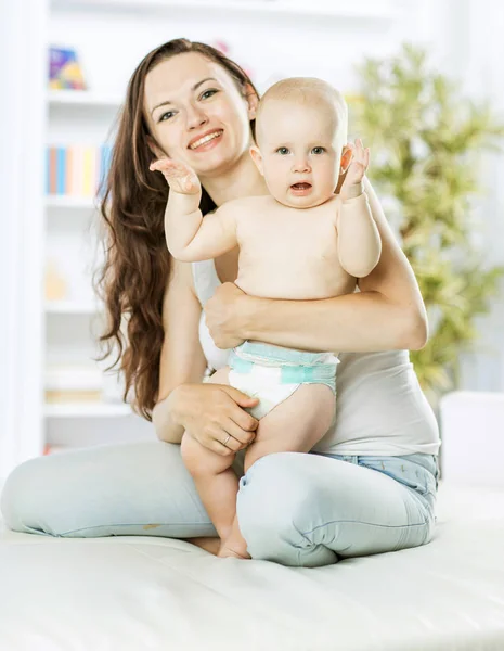 Portrait of happy mom with a year old toddler in the background of a childs room — Stock Photo, Image