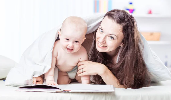 Mãe feliz lendo um livro para ela um ano de idade criança — Fotografia de Stock