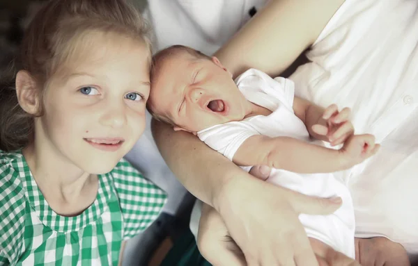 Oudere zus naast een pasgeboren baby — Stockfoto