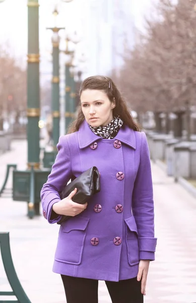 Flicka Fioletovo coat hösten med en påse parken — Stockfoto