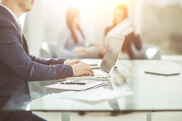 Gestores financeiros trabalhando no laptop com dados financeiros no local de trabalho em um escritório moderno — Fotografia de Stock