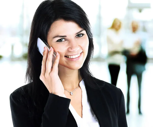 Menina de negócios falando ao telefone no fundo de sua equipe — Fotografia de Stock