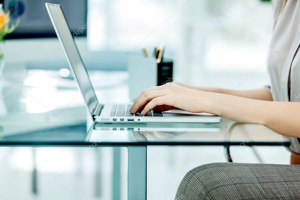 accountant working on a laptop with financial charts on the desktop.