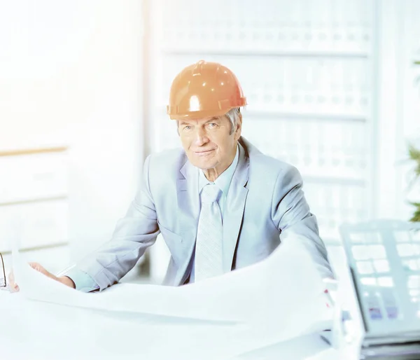 Portrait of professional architect with blueprints sitting behin — Stock Photo, Image