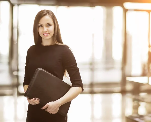 Портрет милой молодой деловой женщины, улыбающейся в офисе, руки папки — стоковое фото