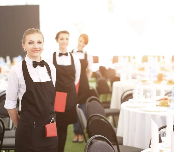 Een grote groep obers en serveersters naast geserveerd tabellen — Stockfoto