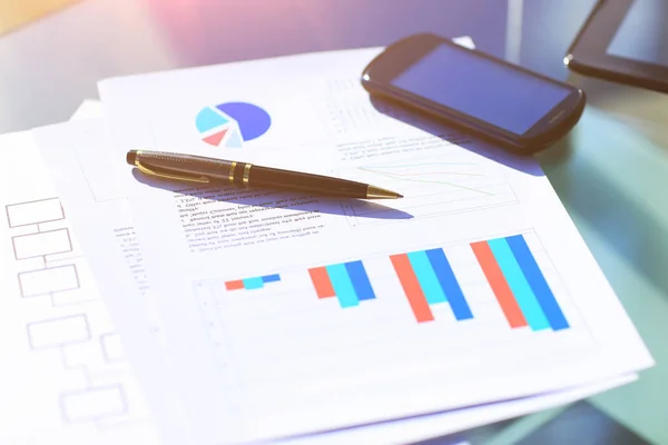 Gráficos financeiros na mesa com tablet e caneta — Fotografia de Stock