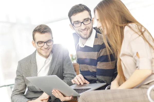 Friendly business team working on laptop and discussing business matters — Stock Photo, Image