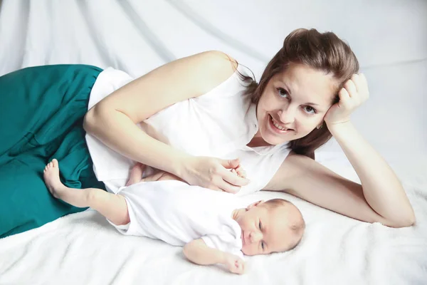 Mutlu anne ve bebek kanepede yalan — Stok fotoğraf