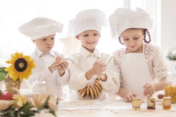 Счастливые маленькие дети в образе повара для приготовления вкусных блюд — стоковое фото