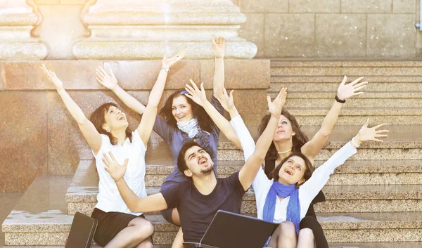 Eine Gruppe fröhlicher Schüler hebt bei sonnigem Wetter freudig die Hände — Stockfoto