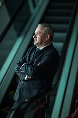 karanlık bir arka plan üzerinde modern bir ofis merdivenlerde durup başarılı iş adamı
