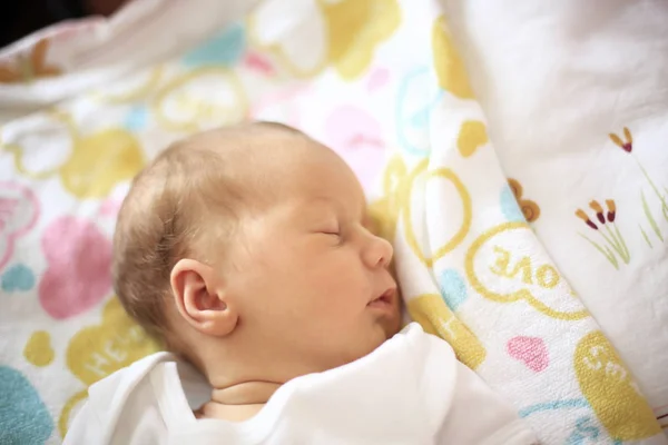 Nyfödda barn sover i spjälsängen på en filt. — Stockfoto