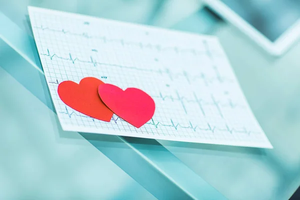 Gezondheid concept: twee rode papier hart op het elektrocardiogram, de cardioloog. — Stockfoto