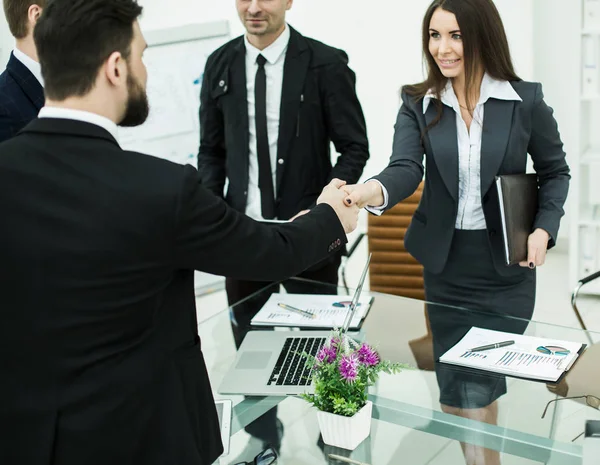 Apretón de manos socios de negocios en la reunión cerca del escritorio en una oficina moderna — Foto de Stock