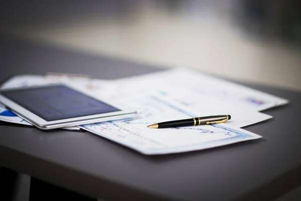 Tablet PC en financiële diagrammen op de werkplek — Stockfoto