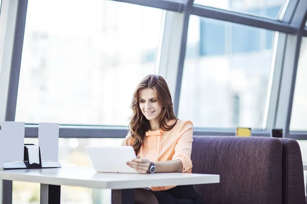 Femme d'affaires réussie avec tablette numérique assis au bureau dans le bureau spacieux — Photo