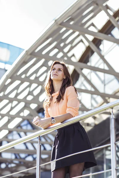 Successful business woman standing on the balcony of the modern office and looks into the distance. — Stock Photo, Image