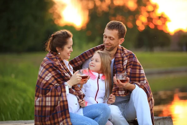Conceito de criar filhos - uma família feliz envolta em um cobertor — Fotografia de Stock