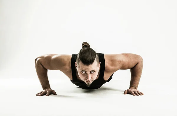 Bodybuilding allenatore esegue push-UPS.photo su uno sfondo bianco — Foto Stock
