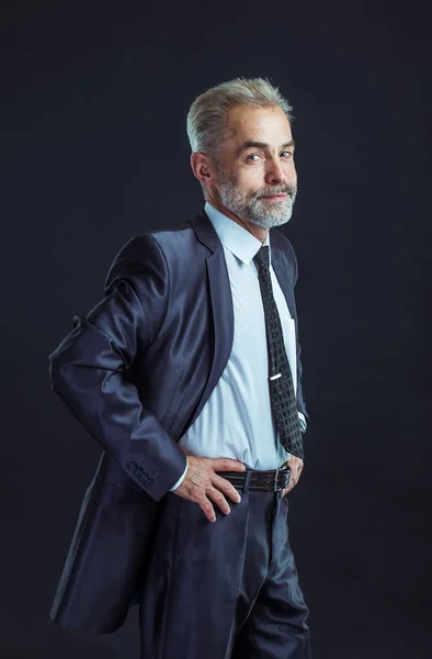 Porträt eines selbstbewussten Geschäftsmannes im Business-Anzug auf schwarzem Hintergrund — Stockfoto