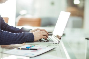 modern bir ofiste işyerinde finansal veriler ile dizüstü bilgisayar üzerinde çalışan mali yöneticisini