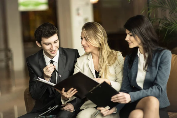 Business team bespreken werkdocumenten zittend op de Bank in de lobby van een modern kantoor — Stockfoto