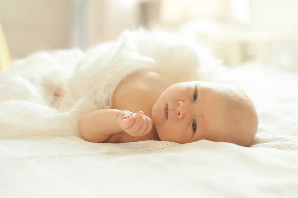 Portret van een pasgeboren baby in het bed van de ouders. — Stockfoto