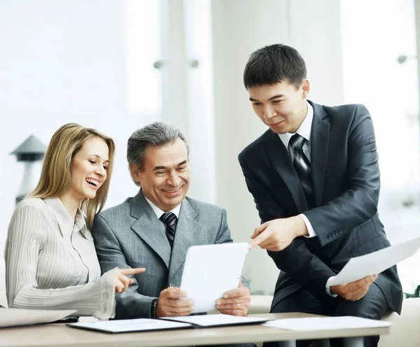 Un grupo empresarial exitoso discute un plan de trabajo usando una tableta —  Fotos de Stock