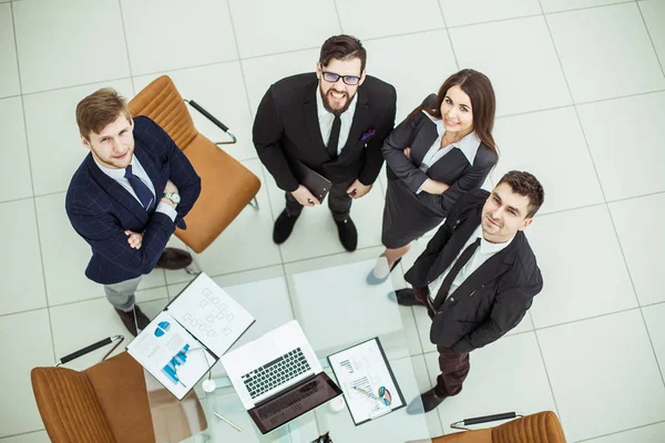 Professionelles Business-Team, das in der Nähe des Desktops nach oben schaut — Stockfoto