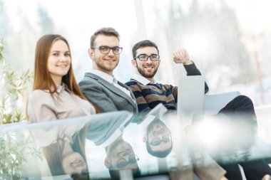 çalışanların ofis lobisinde oturan bir dizüstü bilgisayar ile