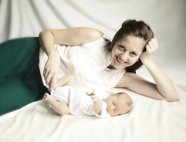 Concepto de felicidad familiar - madre feliz acostada junto al bebé en — Foto de Stock