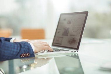 İşyerinde dizüstü bilgisayarda çalışan başarılı bir iş adamı.