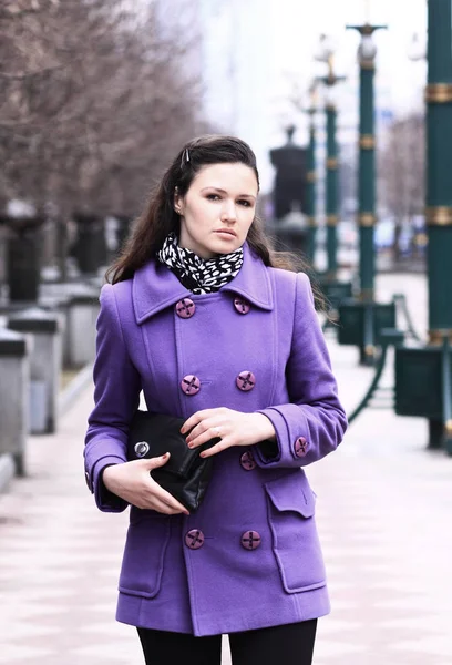 Hermosa chica en un abrigo en la calle con una bolsa —  Fotos de Stock