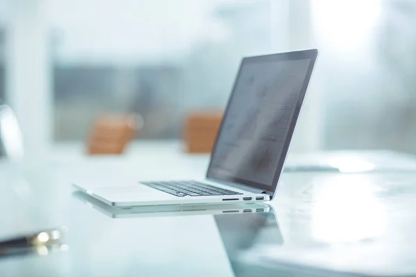 Ноутбук з фінансовим графом на екрані на робочому місці бізнесмена . — стокове фото