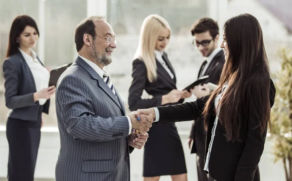 Benvenuto stretta di mano tra avvocato e cliente sullo sfondo del team di lavoro — Foto Stock