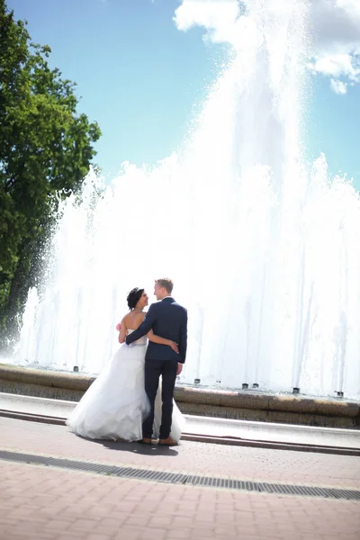 Lyckliga bruden och brudgummen står på torget — Stockfoto