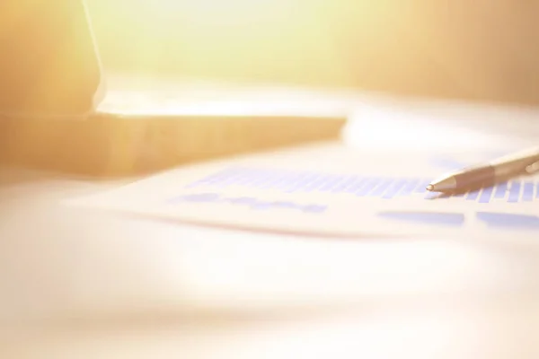 Geschäftshintergrund: Laptop, Finanzkarte und Stift am Büroarbeitsplatz — Stockfoto