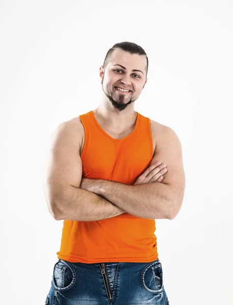 Porträtt av en sportig kille - bodybuilder i jeans och orange t-shi — Stockfoto