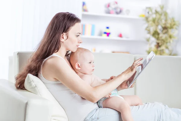 Happy mother showing his year-old baby pictures on digital tablet — Stock Photo, Image