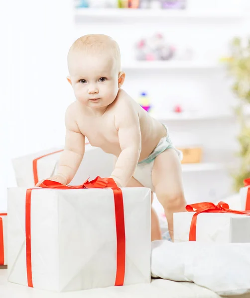 One year old cute baby playing with shopping in boxes on the sofa — Stock Photo, Image