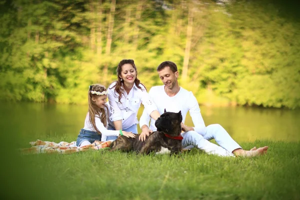 Feliz padre de una hija y una madre embarazada en un picnic . —  Fotos de Stock
