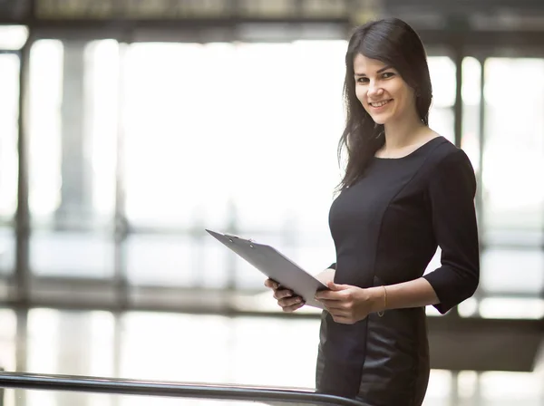 Exitosa mujer de negocios con documentos en el fondo de una amplia oficina . — Foto de Stock