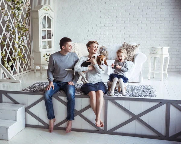 Retrato de una familia feliz y su mascota en un acogedor salón — Foto de Stock