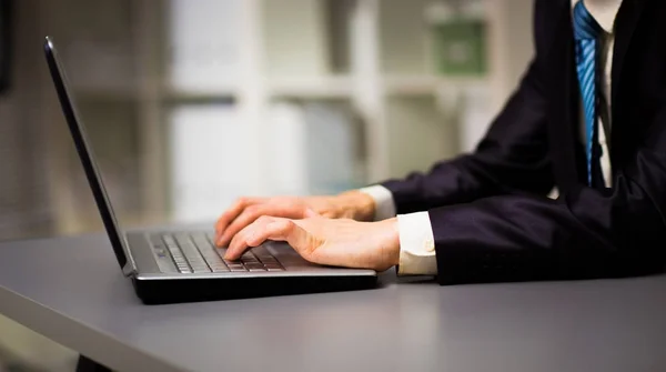 Person tippt auf einem modernen Laptop im Büro — Stockfoto