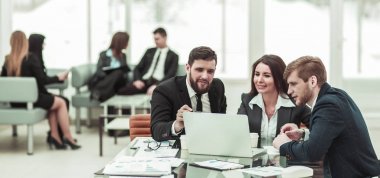 şirket çalışanlarının iş üstünde laptop ile şirketin gelişimi hakkında bilgi